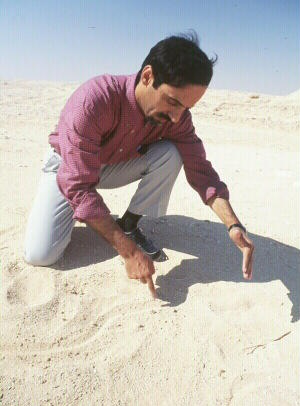 Qurian drawing a map in the sand